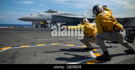 Südchinesisches Meer. 19.. Juli 2022. LT. Eric Stein, rechts, aus dem US-Bundesstaat Kalifornien, und LT. Brandon White, aus Sharpsburg, Ken., Schützen, die dem einzigen vorwärts eingesetzten Flugzeugträger der US-Marine USS Ronald Reagan (CVN 76) zugeordnet sind, starten eine F/A-18E Super Hornet von der Royal Maces of Strike Fighter Squadron (VFA) 27. Die Royal Maces führen Luftangriff- und Streikkräfte-Escort-Missionen sowie Schiffe, Kampfgruppen- und Geheimdiensteintreibemissionen durch. Ronald Reagan, das Flaggschiff der Carrier Strike Group 5, stellt eine kampfbereite Kraft zur Verfügung, die die Vereinigten Staaten schützt und verteidigt Stockfoto