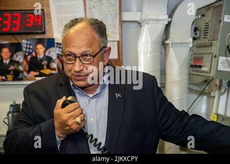 22. Juli 2022 - China Sea - Marinesekretär Carlos Del Toro gibt eine Ankündigung über die 1MC von einem Deckhaus an Bord des einzigen vorwärts eingesetzten Flugzeugträgers der US Navy USS Ronald Reagan (CVN 76). Während des Besuchs von Del Toro hielt er eine Pressekonferenz ab, wandte sich an die Besatzung und traf sich mit Matrosen in der Hangarbucht des Schiffes. Ronald Reagan, das Flaggschiff der Carrier Strike Group 5, stellt eine kampfbereite Kraft zur Verfügung, die die Vereinigten Staaten schützt und verteidigt und Allianzen, Partnerschaften und kollektive maritime Interessen in der Indo-Pazifik-Region unterstützt. (Bild: © U.S. Navy/ZUMA Press Wir Stockfoto