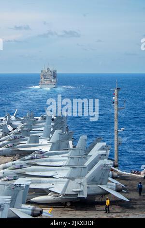 Philippinische See. 2. August 2022. Der einzige vorwärts eingesetzte Flugzeugträger der US-Marine USS Ronald Reagan (CVN 76) nähert sich dem Militär-Sealift-Kommando-Trocken- und Munitionsschiff USNS Carl Brashear (T-AKE 7), um eine Auffüllung auf See in der philippinischen See durchzuführen. Während der Evolution transportierte Carl Brashear Fracht und Ammunition über eine vernetzte und vertikale Nachfüllung zu Ronald Reagan. Ronald Reagan, das Flaggschiff der Carrier Strike Group 5, stellt eine kampfbereite Kraft zur Verfügung, die die Vereinigten Staaten schützt und verteidigt und Allianzen, Partnerschaften und kollektive maritime Interessen unterstützt Stockfoto