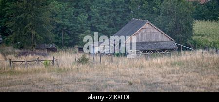 Landschaftlich schöner Blick auf ein altes Bauernhaus aus Holz im Verfall in der ländlichen Landschaft von Siebenbürgen, Rumänien Stockfoto