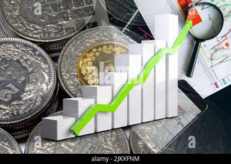 Wirtschaftsdiagramm: Aufwärtspfeil, Frankenmünzen und Börsenkennzahlen Stockfoto