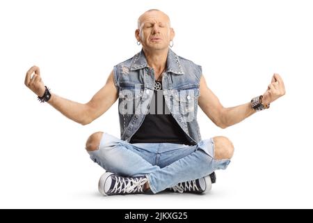 Kahlköpfiger Mann in Jeans sitzt mit gekreuzten Beinen und praktiziert Meditation isoliert auf weißem Hintergrund Stockfoto