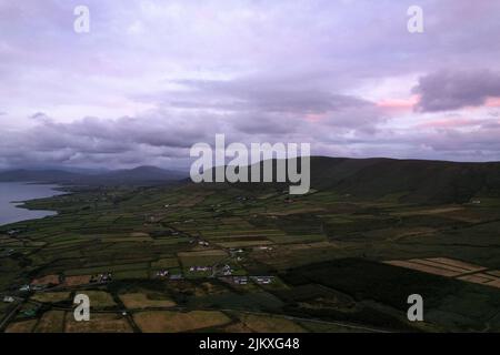 Purpurner Sonnenuntergang über der Portmagee Bay in der Grafschaft Kerry, Irland Stockfoto