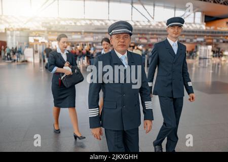 Zwei Piloten, die am Flughafenterminal entlang laufen Stockfoto