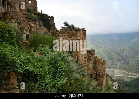 Altes Dorf Gamsutl auf Felsen auf dem Hintergrund der Berge. Erstaunliche Siedlung von Felshäusern auf dem Gipfel des Berges. Attraktion von Dagestan - Dorf von Stockfoto