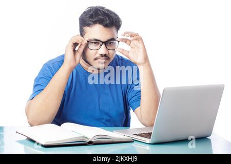 Junge Studentin in Brillen, während sie den Online-Kurs auf einem Laptop studiert Stockfoto