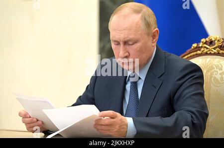 Moskau, Russland. 03. August 2022. Der russische Präsident Wladimir Putin überprüft seine Notizen während eines Telefonkonferenz-Treffens mit dem amtierenden Gouverneur der Region Jaroslawl, Michail Jewrajew, vom Kreml, am 3. August 2022 in Moskau, Russland. Quelle: Mikhail Klimentyev/Kremlin Pool/Alamy Live News Stockfoto