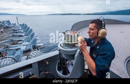 Straße Von San Bernardino. 1. August 2022. Quartermaster 2. Class Kevin Fernandez aus Dover, N.J., steht an Bord des einzigen vorwärts eingesetzten Flugzeugträgers der US Navy USS Ronald Reagan (CVN 76) während einer Inseldurchfahrt durch die San Bernardino Strait, 30. Juli 2022. Ronald Reagan, das Flaggschiff der Carrier Strike Group 5, stellt eine kampfbereite Kraft zur Verfügung, die die Vereinigten Staaten schützt und verteidigt und Allianzen, Partnerschaften und kollektive maritime Interessen in der Indo-Pazifik-Region unterstützt. Quelle: U.S. Navy/ZUMA Press Wire Service/ZUMAPRESS.com/Alamy Live News Stockfoto