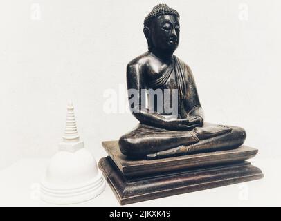 Eine Holzstatue von lord buddha und ein weißer Mustertempel aus Lehm Stockfoto