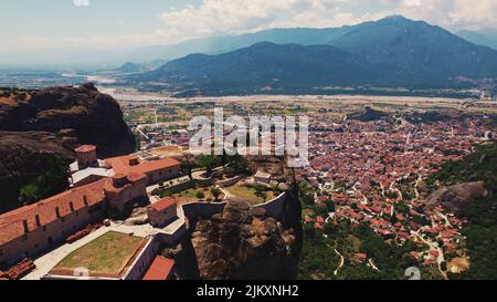 Meteora in Griechenland und seine berühmten östlichen orthodoxen Klöster, die auf den Felsformationen platziert sind. In der Nähe Dorf und ein Berg im Hintergrund. Hochwertige Fotos Stockfoto