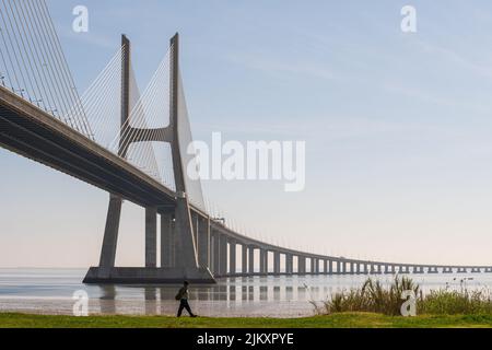 Ein Mann, der die Vasco da Gama Brücke im Parque das Nacoes, Lissabon, entlang läuft Stockfoto