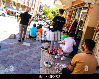 Männer beten während der salah auf der Straße in der Nähe der Moschee in Esenler, İstanbul, Türkei Stockfoto