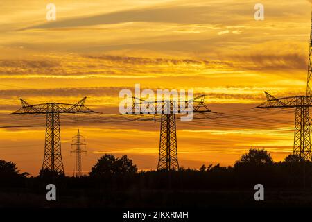 Strommasten in Deutschland bei Sonnenuntergang Stockfoto