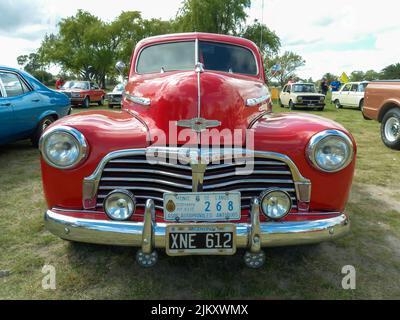 Chascomus, Argentinien - 9. Apr 2022: Der alte rote Chevrolet Chevy Stylesmaster 1948 Coupé von General Motors parkte auf dem Land. Naturrasen Stockfoto