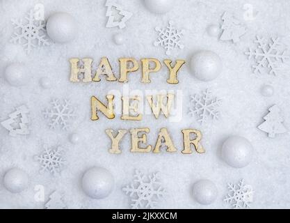 Happy New Year Karte, weißer Schnee, Schneeflocken und Text in Holzbuchstaben. Stockfoto