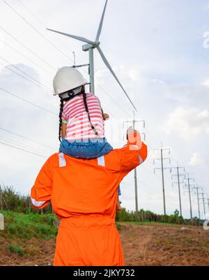 Ingenieure nehmen ihre Tochter mit auf eine Tour durch Windkraftanlagen. Windturbinen sind eine alternative Stromquelle, um in Zukunft nachhaltige Ressourcen zu sein. Stockfoto