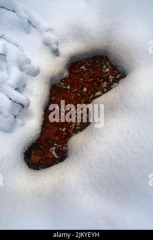 Auftauende Öffnung im verschneiten Eis des Stromes Stockfoto