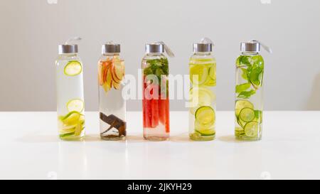 Die frischen Getränke in kleinen Flaschen auf weißem Tisch Stockfoto