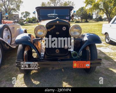 Chascomus, Argentinien - 9. Apr 2022: Altes gelbes Chrysler Plymouth phaeton vier Türen um 1930 auf dem Land geparkt. Natur Gras und Bäume backgr Stockfoto