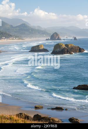 An einem nebligen Abend am Cannon Beach in Oregon erheben sich die Wellen des Pazifischen Ozeans Stockfoto