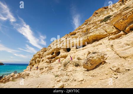 Matala-Strand mit Höhlen auf den Felsen, die als römische Friedhof verwendet wurden und auf das Jahrzehnt der 70er Jahre waren lebenden Hippies aus aller Welt, Crete, Stockfoto
