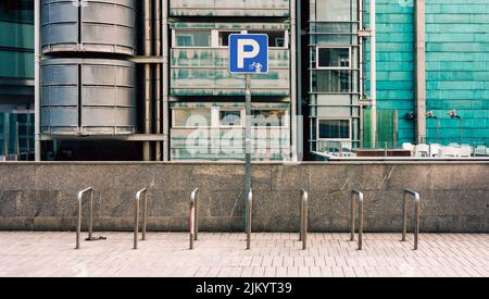 Fahrradparkplatz auf der Straße mit blauem Schild Stockfoto