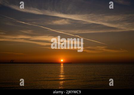 Ein faszinierender Blick auf den goldenen Sonnenaufgang über dem Meer Stockfoto