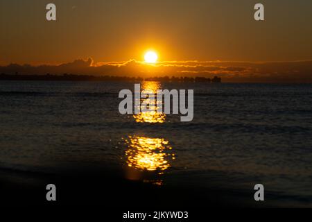 Ein faszinierender Blick auf den goldenen Sonnenaufgang über dem Meer Stockfoto