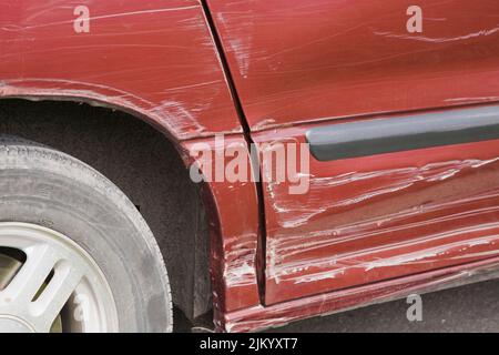 Nahaufnahme der versehentlichen Seitentür des rot gefärbten Mini Van-Fahrzeugs. Stockfoto