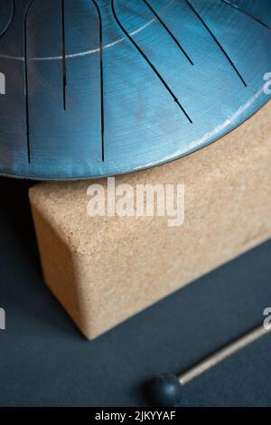 Eine vertikale Aufnahme von Steel Tongue Drum auf Stein Stockfoto