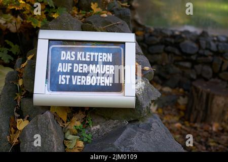 Verbotsschild in einem Park in Deutschland. Übersetzung: Das Klettern an der Wand ist verboten Stockfoto