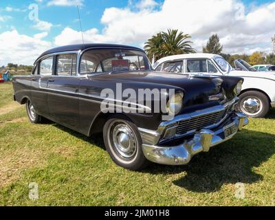 Chascomus, Argentinien - Apr 9, 2022 - Alte schwarze Chevrolet Chevy Bel Air Limousine viertürig 1956 geparkt auf dem Gras. Oldtimer-Show. Copyspace Stockfoto