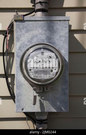 Strom-Messgerät für Wasserkraft an der Außenwand eines Hauses. Stockfoto