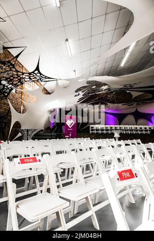 Die Reihen leerer weißer Stühle im Konferenzsaal Stockfoto