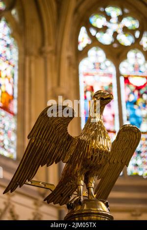 Eine vertikale Aufnahme einer Bronzestatue eines goldenen Adlers im Inneren einer Kirche Stockfoto