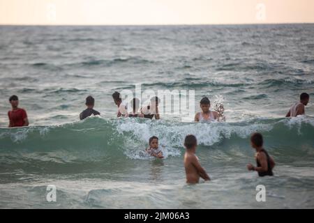 Gaza, Palästina. 03. August 2022. Die Palästinenser sahen ein Bad am Mittelmeerstrand, während sie der schwellenden Hitze in Khan Yunis im südlichen Gazastreifen entflohen waren. Kredit: SOPA Images Limited/Alamy Live Nachrichten Stockfoto