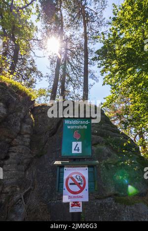 Lohmen, Deutschland. 03. August 2022. An der Bastei in der Sächsischen Schweiz hängt ein Schild mit Waldbrandwarnstufe 4 und Rauchverbot. Der Nationalpark ist seit mehreren Wochen in Flammen. (To dpa: 'Verbrannte Erde: Hoffnung ruht jetzt auf dem Kreislauf der Natur') Quelle: Daniel Schäfer/dpa/Daniel Schäfer/dpa/Alamy Live News Stockfoto