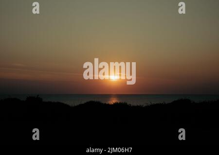 Sonnenuntergang über dem Meer in Hunstanton in Norfolk. Stockfoto