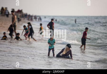 Gaza, Palästina. 03. August 2022. Die Palästinenser sahen ein Bad am Mittelmeerstrand, während sie der schwellenden Hitze in Khan Yunis im südlichen Gazastreifen entflohen waren. (Foto von Yousef Masoud/SOPA Images/Sipa USA) Quelle: SIPA USA/Alamy Live News Stockfoto