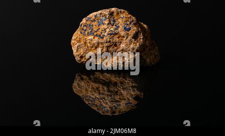 Eine Nahaufnahme eines kleinen blauen Azurit und Quarzfragmente auf rohem Stein auf schwarzem Hintergrund Stockfoto