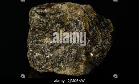 Eine Nahaufnahme eines Goldenen Quarzes mit mineralischen Pyrit, isoliert auf einer reflektierenden schwarzen Oberfläche Stockfoto