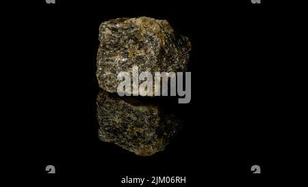 Eine Nahaufnahme eines Goldenen Quarzes mit mineralischen Pyrit, isoliert auf einer reflektierenden schwarzen Oberfläche Stockfoto