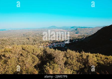 Eine Vogelperspektive auf eine kleine Stadt in einem Tal inmitten dichter Wälder und Hügel Stockfoto