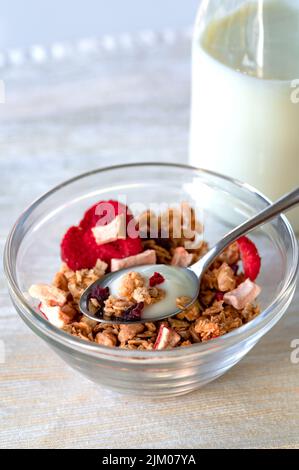Eine Schüssel Haferflocken mit einer Flasche Joghurt Stockfoto