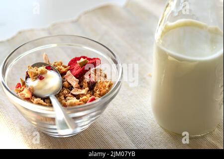 Eine Schüssel Haferflocken mit einer Flasche Joghurt Stockfoto