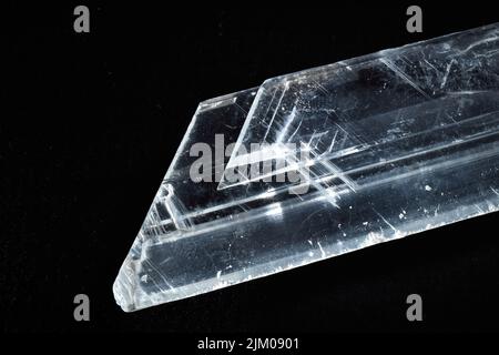 Eine Nahaufnahme eines seltenen mineralischen, ungeschnitten transparenten Kristalls auf schwarzem Hintergrund Stockfoto