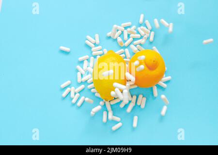 Vitamin C Tabletten.viele Pillen und Zitrusfrüchte. Fliegende weiße Vitamin-C-Pillen und Zitronen auf blauem Hintergrund.natürliches Fruchtvitamin C.Immunität Stockfoto