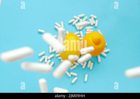 Vitamin C Tabletten.viele Pillen und Zitrusfrüchte. Vitamin C weiße Pillen und Zitronen auf blauem Hintergrund.natürliches Fruchtvitamin C.Immunitätsmittel Stockfoto