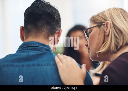 Beratung, Therapie und Unterstützung für traurigen Ehemann und Ehefrau. .Fürsorgliche, liebevolle und freundliche Frau tröstet und unterstützt ihren Partner in einer schwierigen Stockfoto