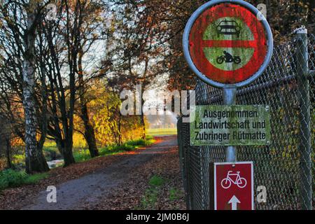 Die Nahaufnahme der Straße und ein Fahrradschild mit einem Parkweg im Hintergrund Stockfoto